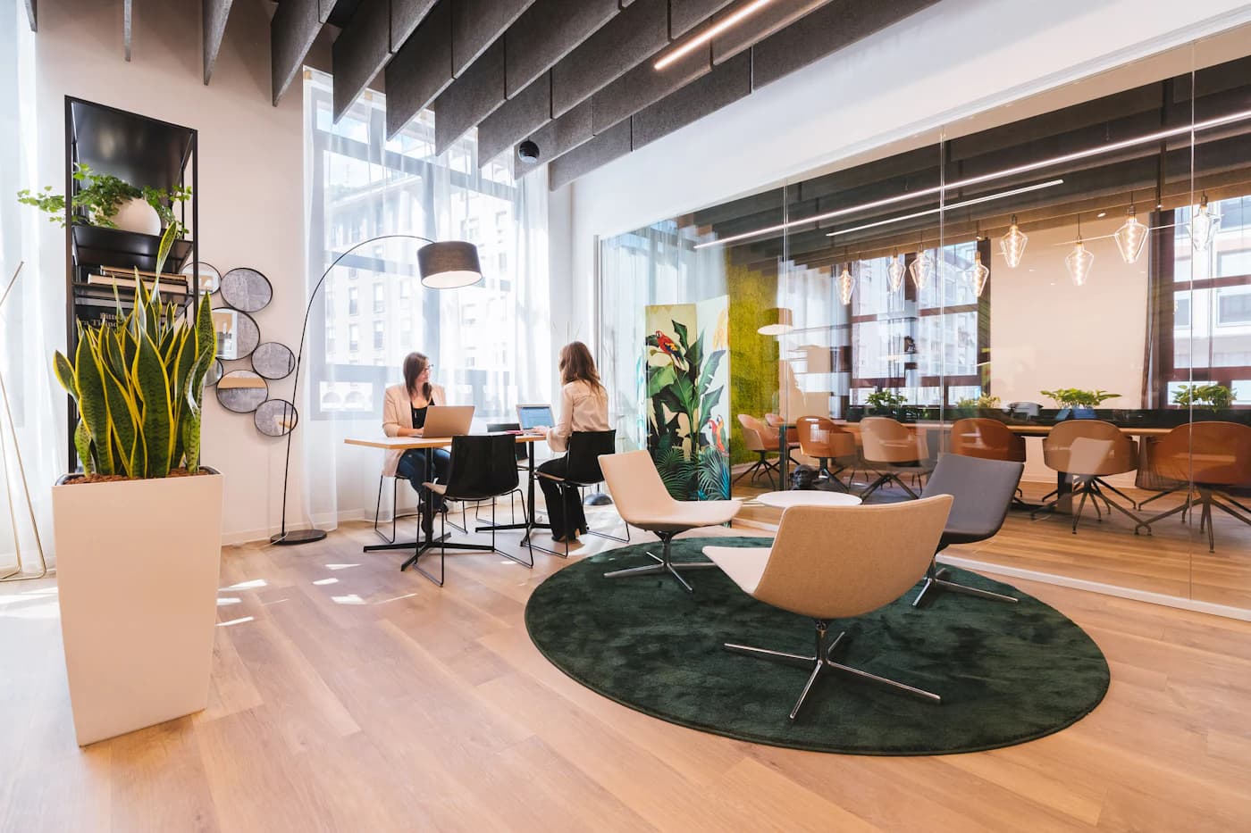 A sunlit modern office with people working quietly in the background.