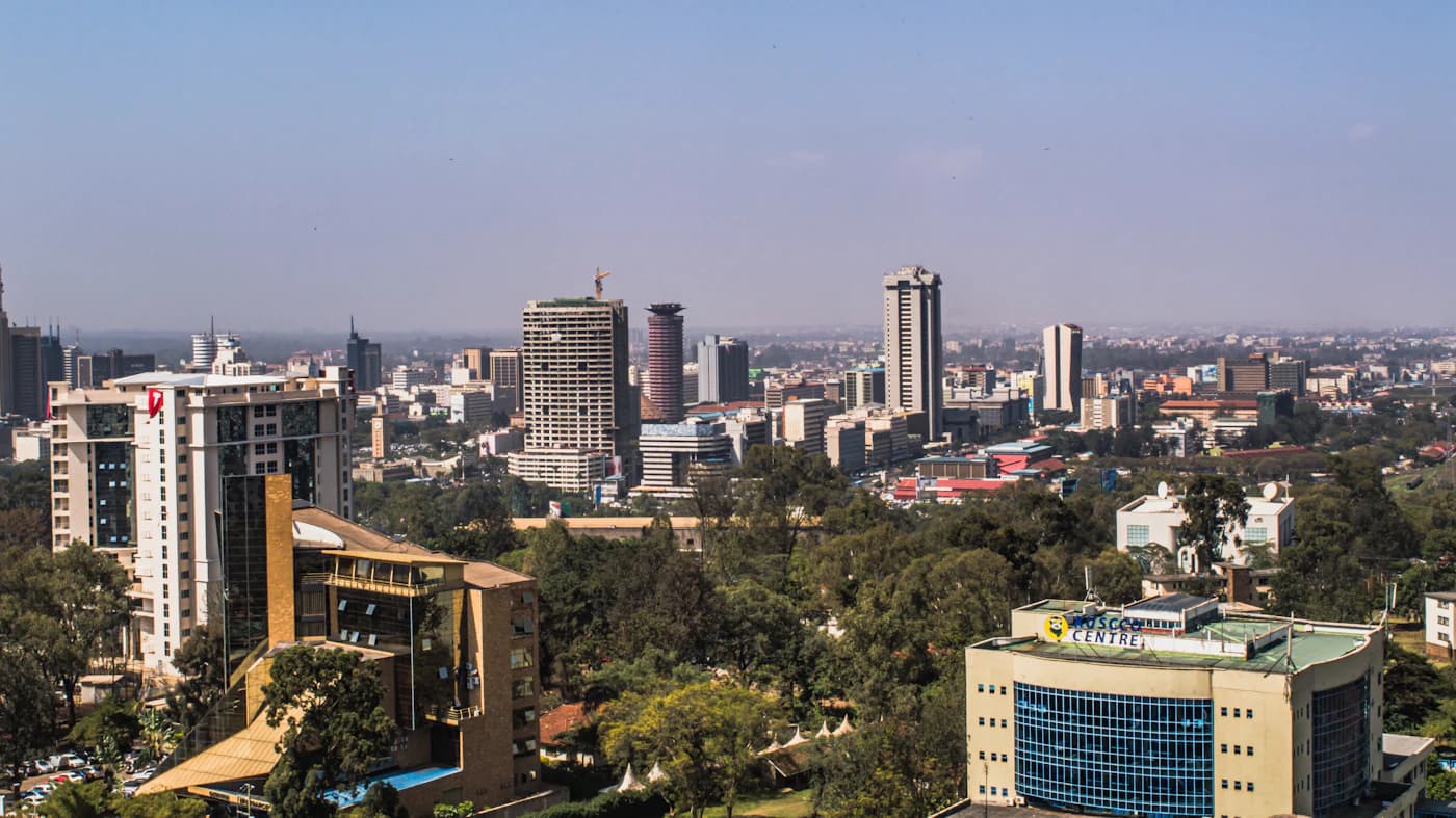 The Nairobi city skyline under a bright midday sky.