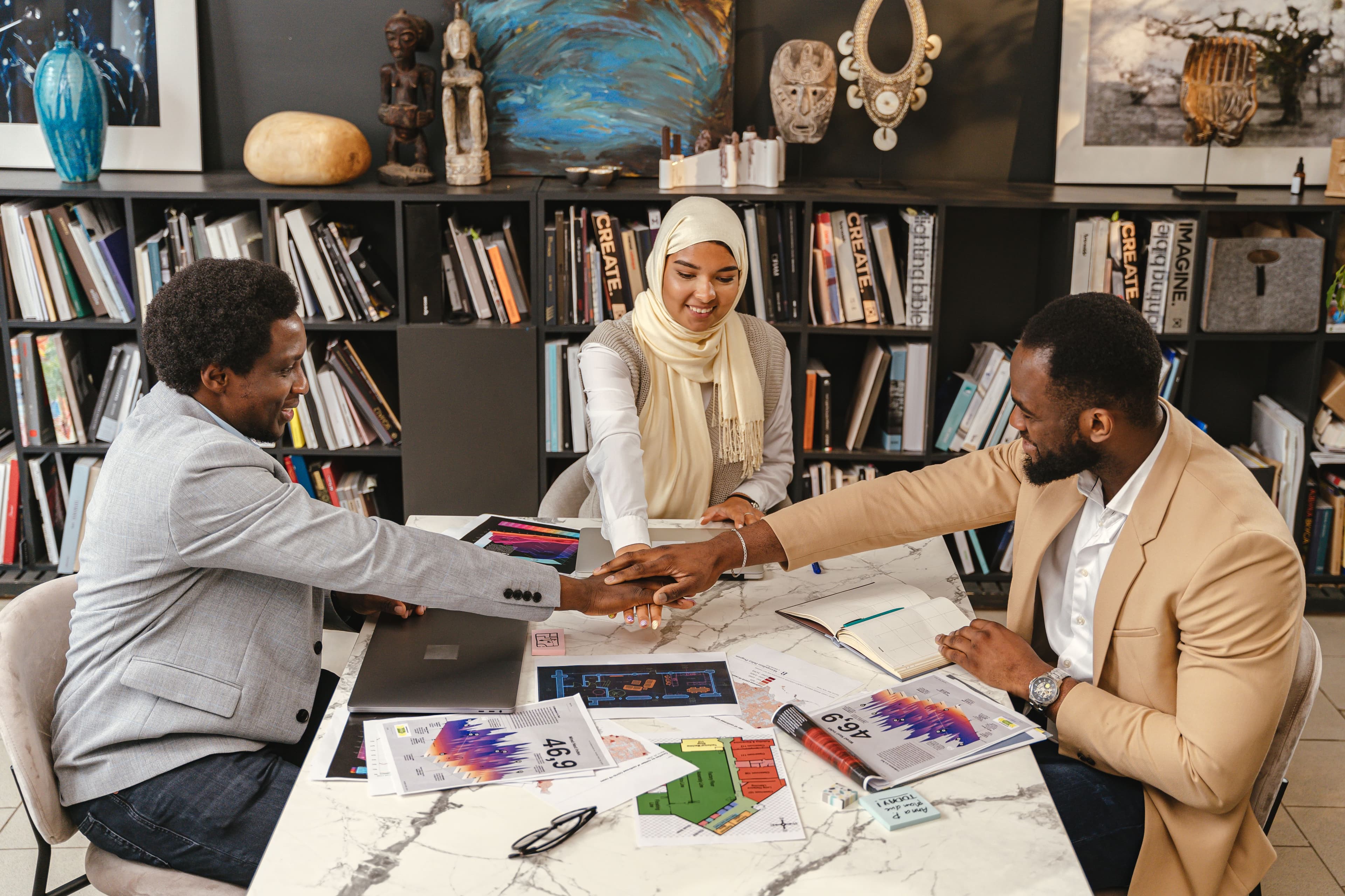 A team working together around a table covered in plans and notes.